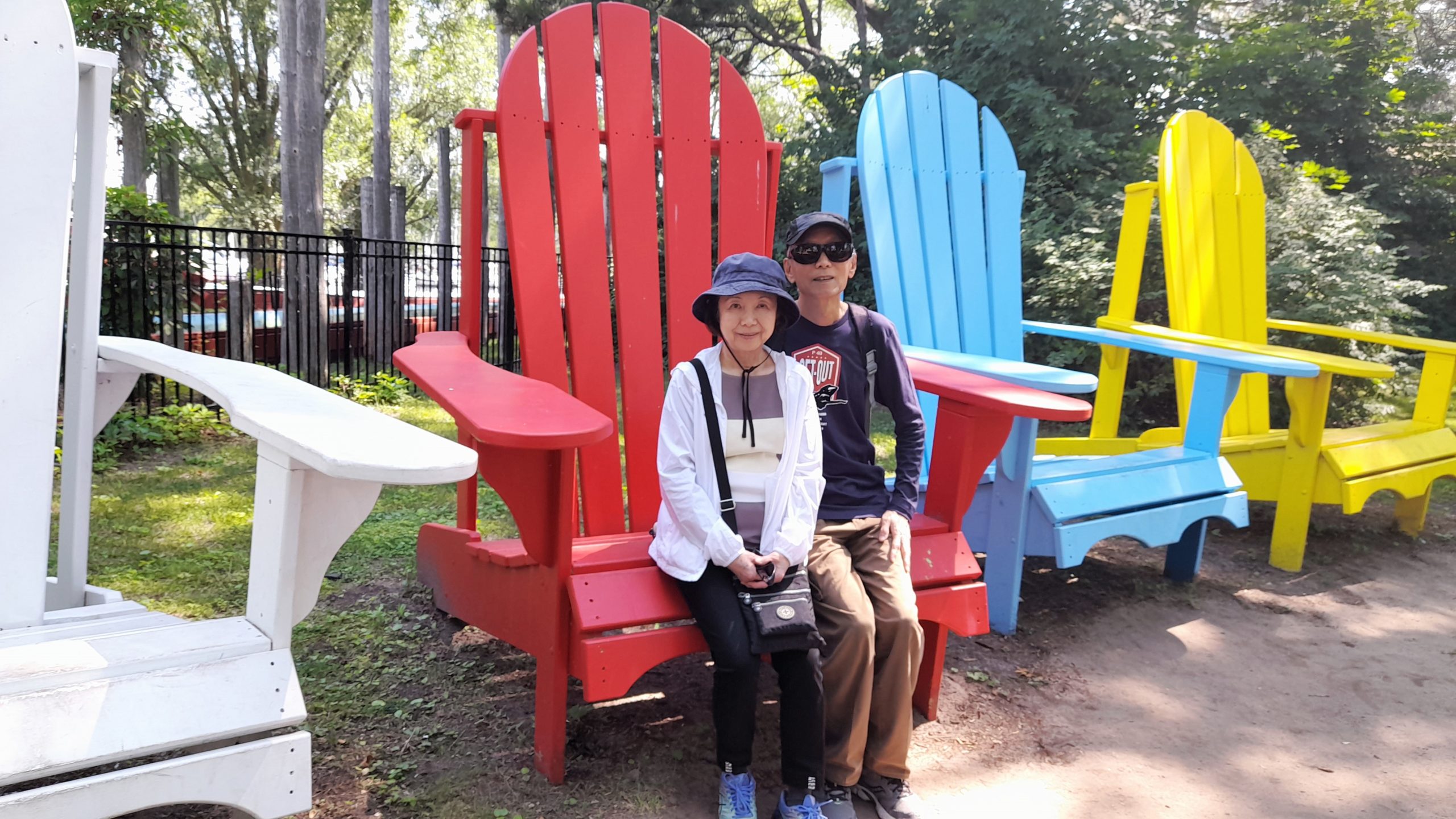 two people sitting on a large Muskoka chair